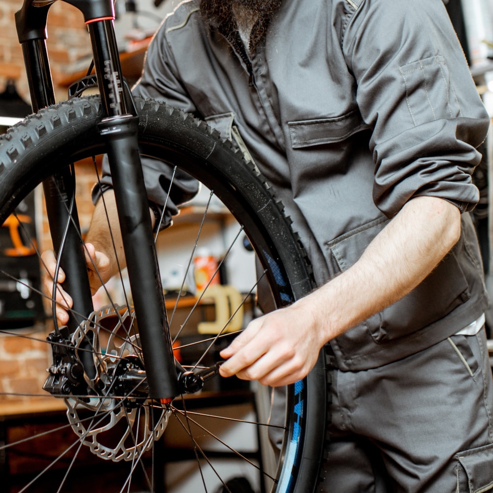 Repairman with bicycle at the workshop